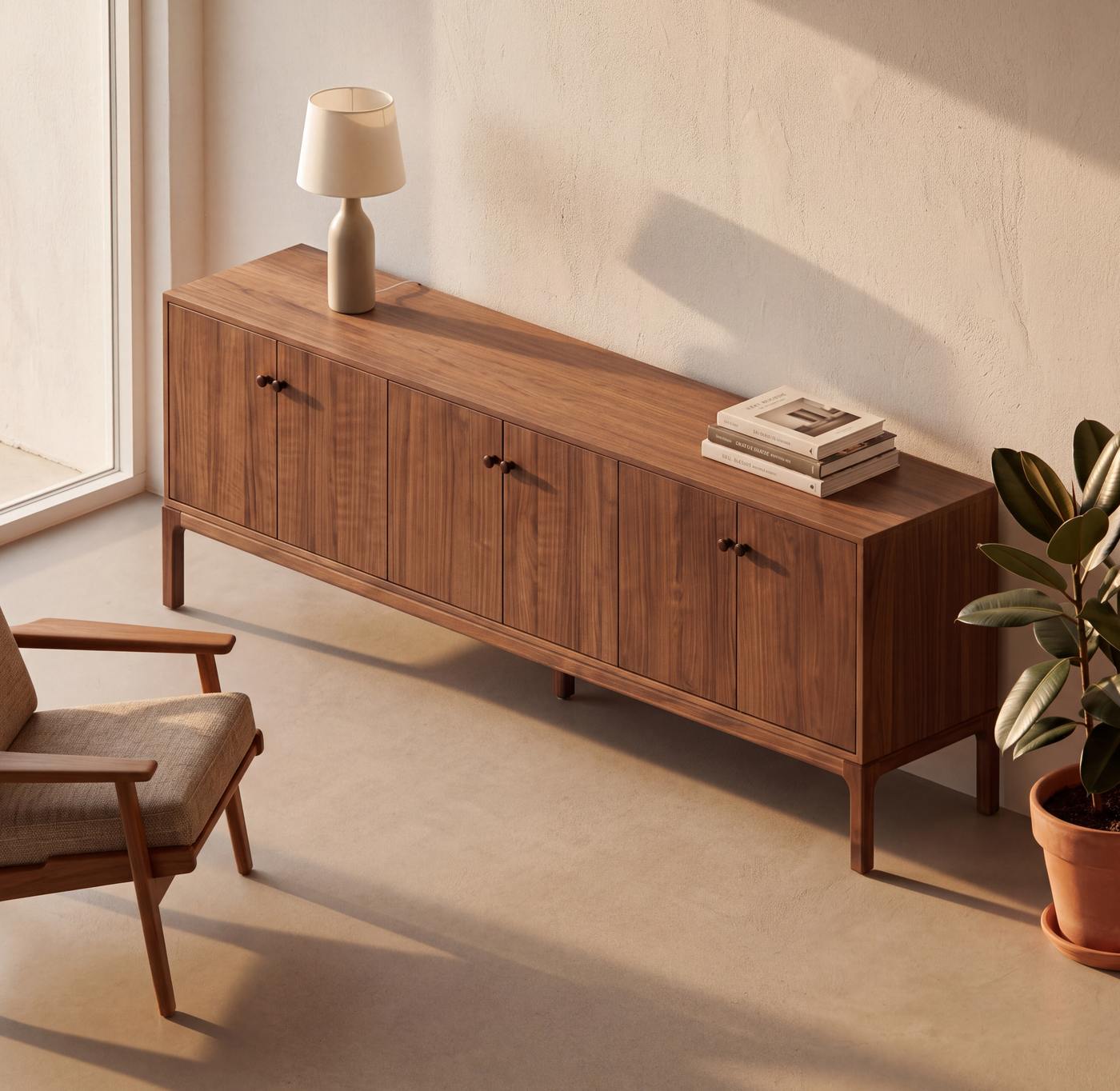 Walnut credenza styled in a sunlit room with a table lamp, books and a potted plant